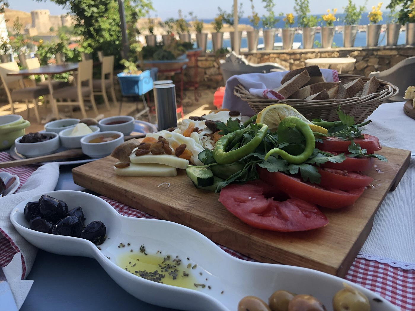 Açık havada, ahşap tahta üzerinde domates, biber, peynir ve zeytinden oluşan bir sofra